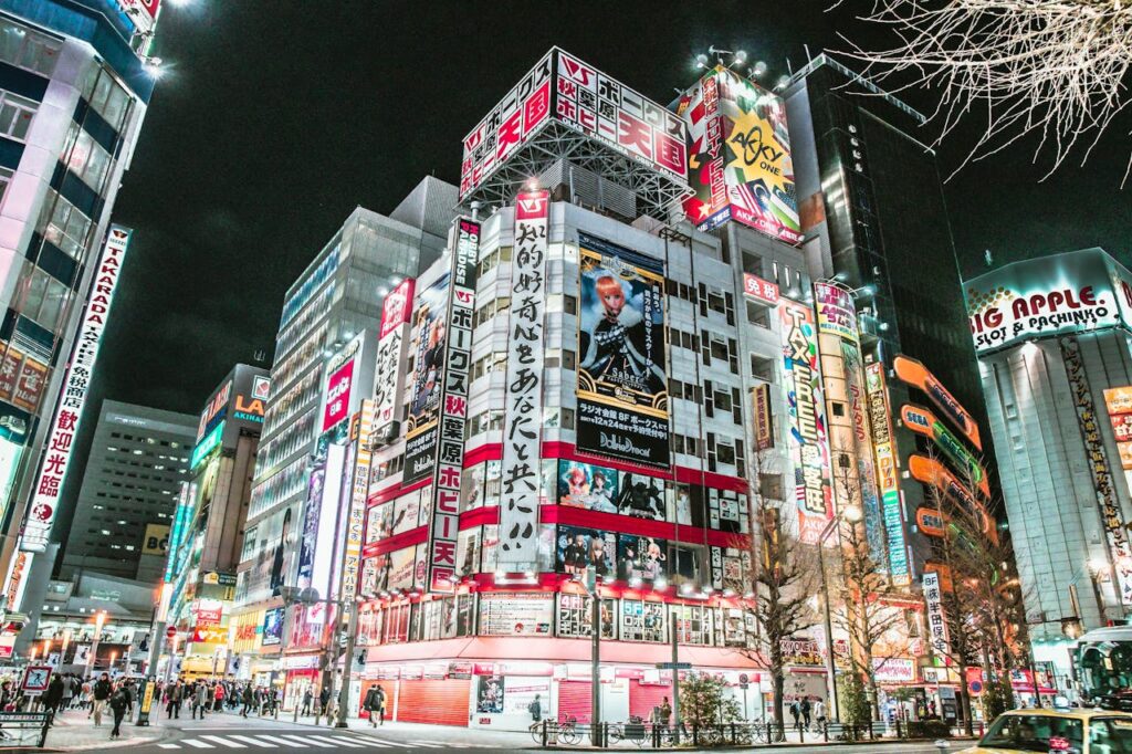 Dynamic view of Akihabara's illuminated streets at night showcasing neon signs and bustling city life in Tokyo.